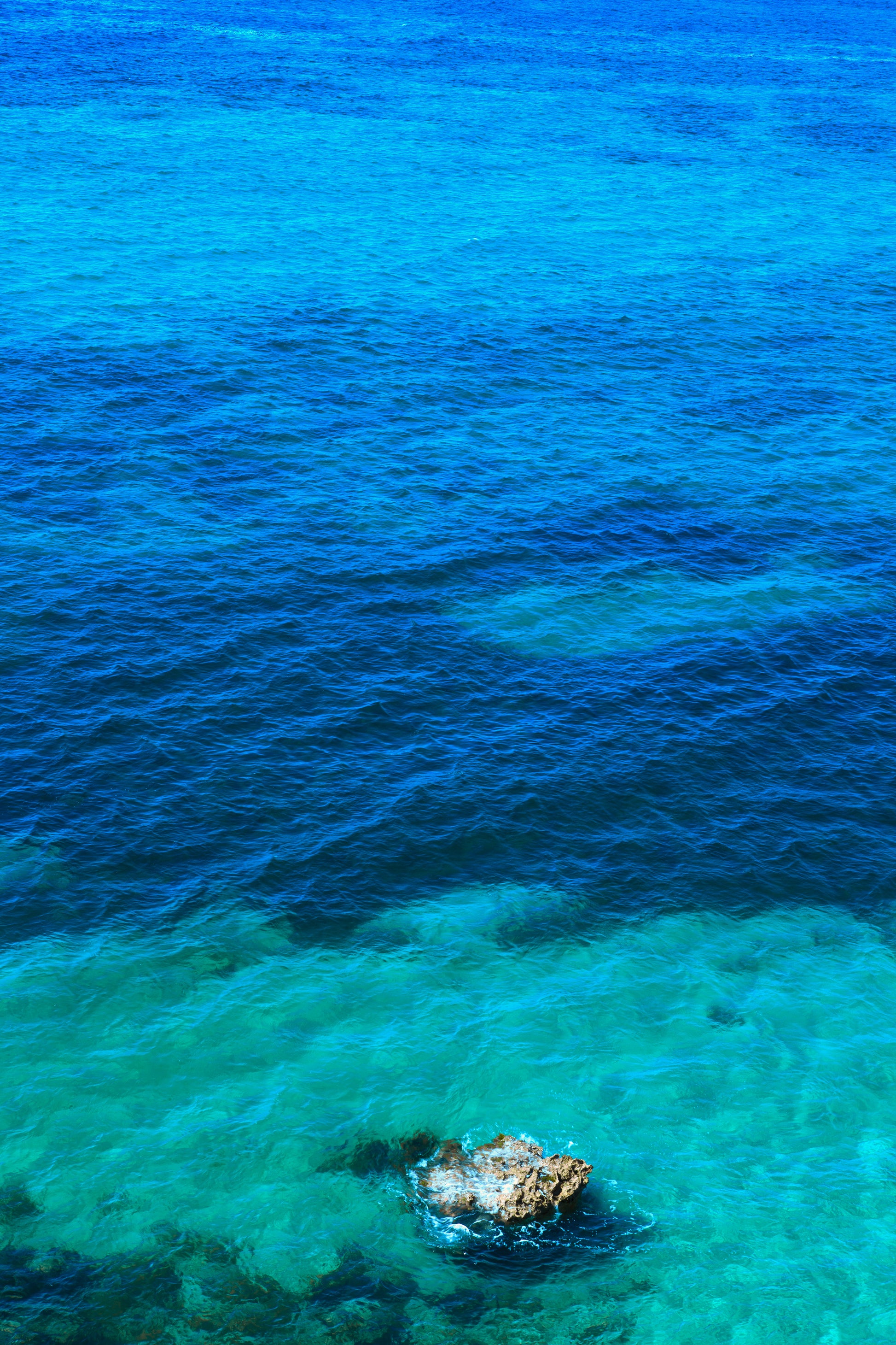 single rock sitting in clear water